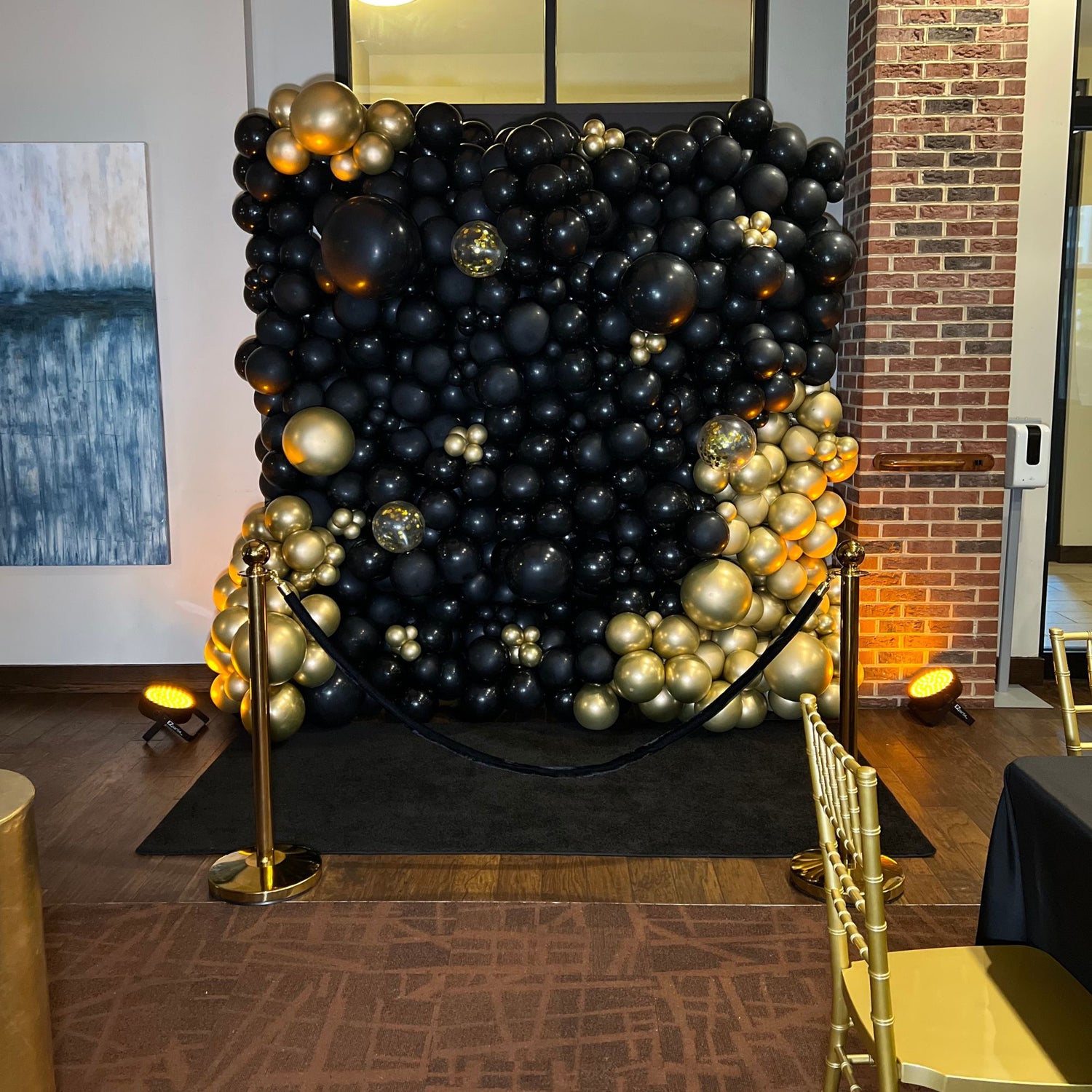 Black and gold balloon wall with confetti accent balloons