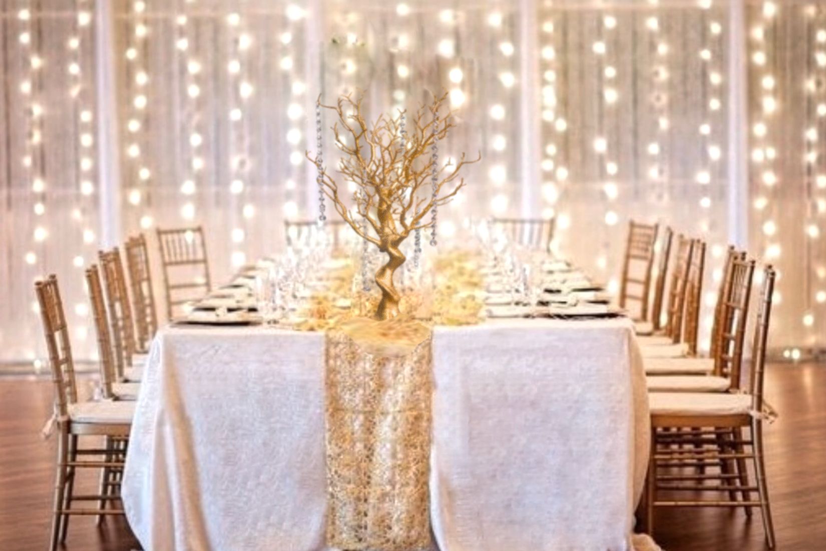 White panel backdrop with twinkle fairy lights. Gold chiavari chairs with gold manzanita tree.